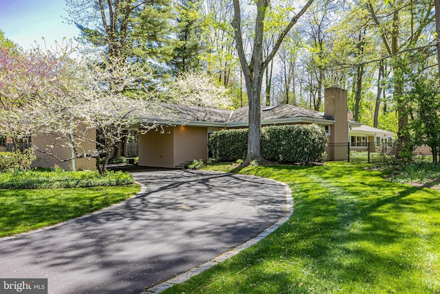 74 Wilson Rd, Princeton, NJ 08540 - single story home featuring stucco siding, a chimney, a front yard, and aphalt driveway