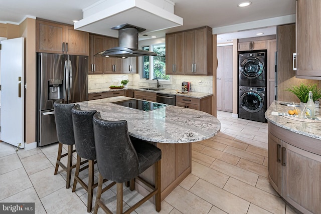 74 Wilson Rd, Princeton, NJ 08540 - kitchen with appliances with stainless steel finishes, light stone counters, stacked washer / dryer, and island range hood