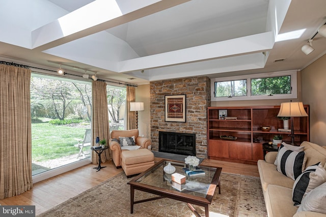 74 Wilson Rd, Princeton, NJ 08540 - living room featuring visible vents, rail lighting, wood finished floors, and a stone fireplace