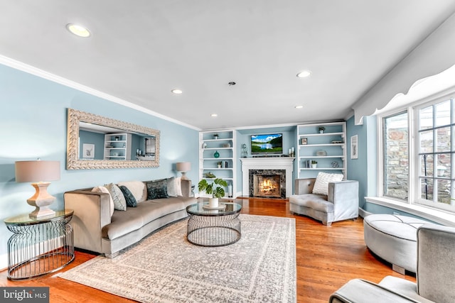 living room with ornamental molding, a premium fireplace, and light hardwood / wood-style floors