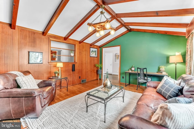 living room featuring a notable chandelier, wooden walls, lofted ceiling with beams, and light wood-type flooring