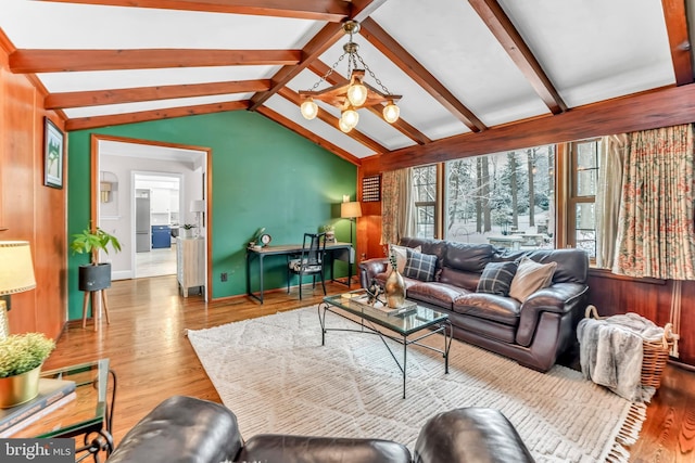 living room with hardwood / wood-style flooring and vaulted ceiling with beams