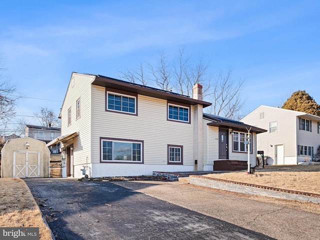 split level home with a storage shed