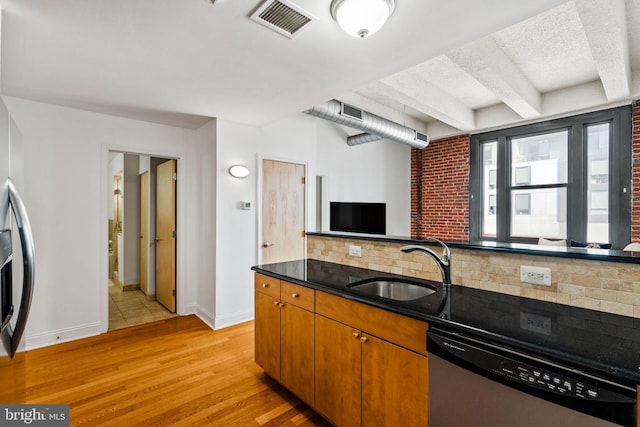 kitchen with tasteful backsplash, visible vents, dishwasher, light wood-type flooring, and a sink