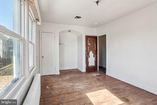 unfurnished room featuring radiator and dark hardwood / wood-style flooring