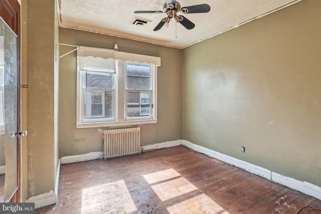 unfurnished room with wood-type flooring, radiator heating unit, and ceiling fan