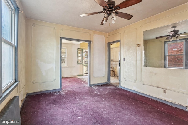 empty room with radiator heating unit and ceiling fan