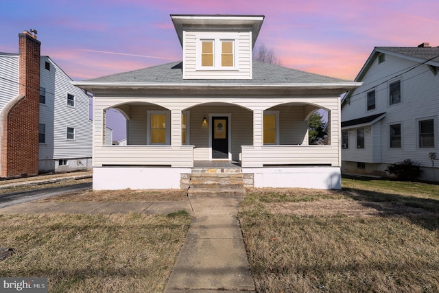 view of front facade with a yard and covered porch