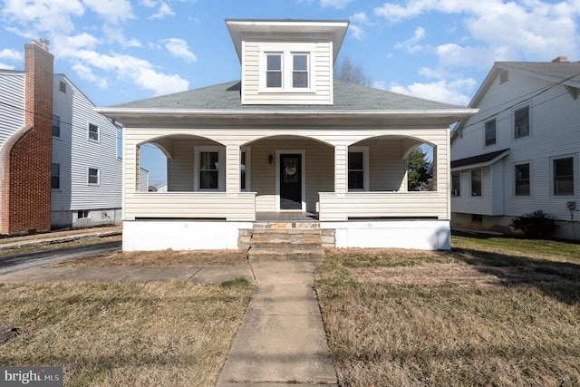 bungalow-style home with covered porch and a front lawn