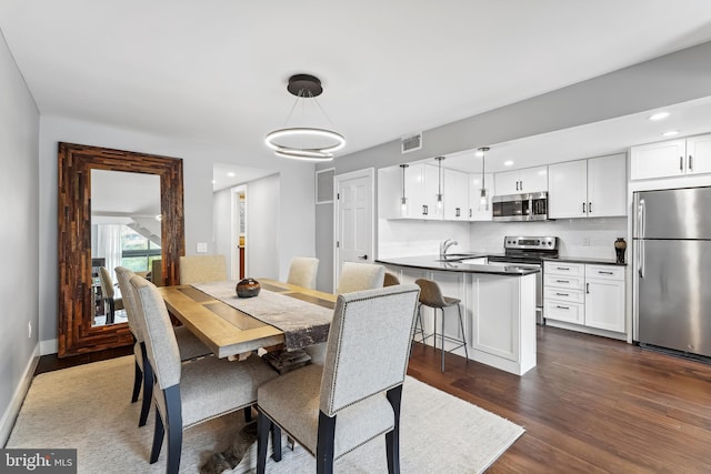 dining room with sink and dark wood-type flooring