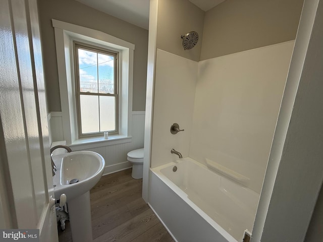 bathroom featuring toilet, shower / bath combination, and hardwood / wood-style floors