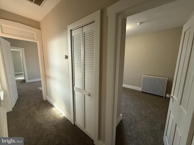 corridor featuring radiator heating unit and dark colored carpet