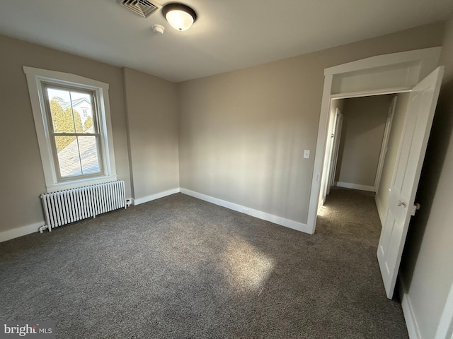 carpeted spare room featuring radiator