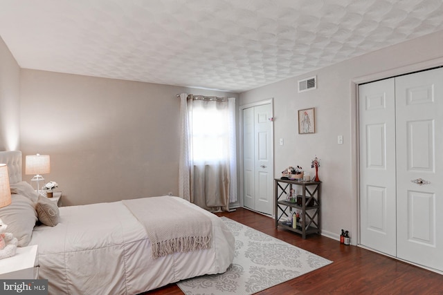 bedroom with dark hardwood / wood-style floors and a textured ceiling