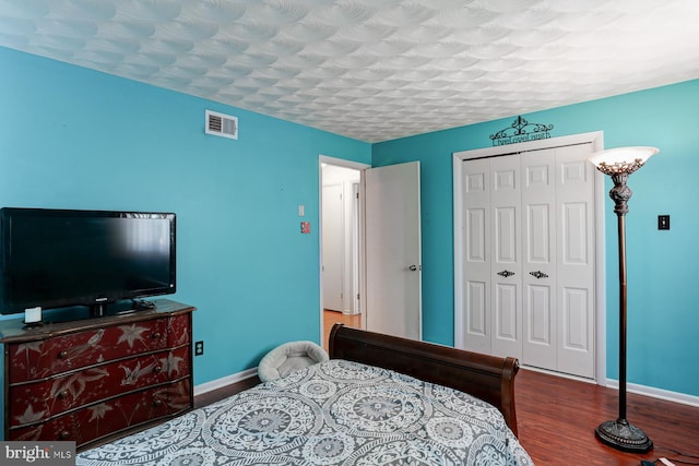 bedroom with wood-type flooring, a closet, and a textured ceiling