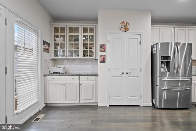 kitchen with decorative backsplash, white cabinetry, dark hardwood / wood-style floors, and stainless steel refrigerator with ice dispenser