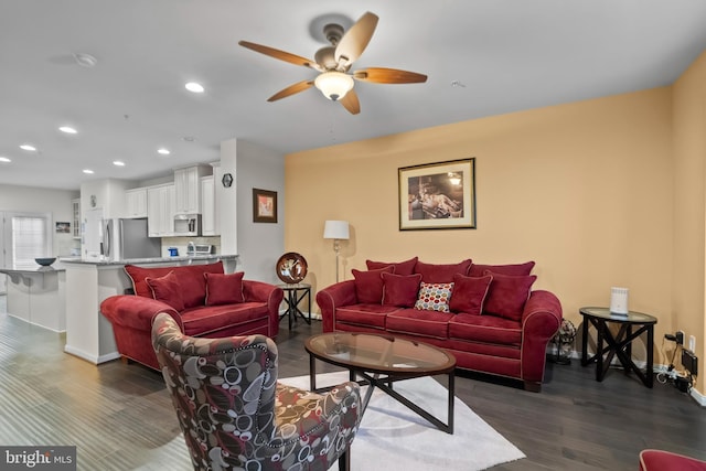 living room with ceiling fan and dark hardwood / wood-style flooring