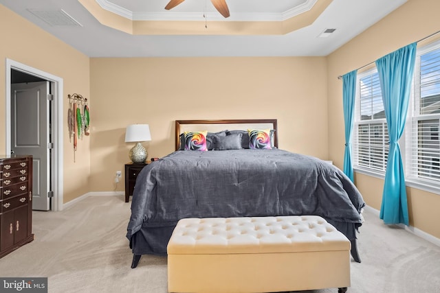 bedroom featuring a raised ceiling, ceiling fan, light carpet, and crown molding