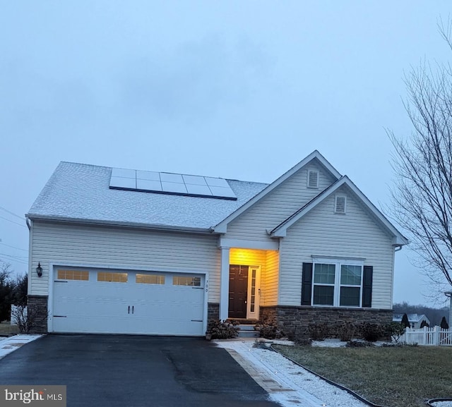 view of front of property with a garage and solar panels