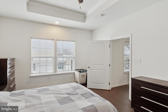 bedroom with a raised ceiling, ornamental molding, ceiling fan, and dark hardwood / wood-style flooring