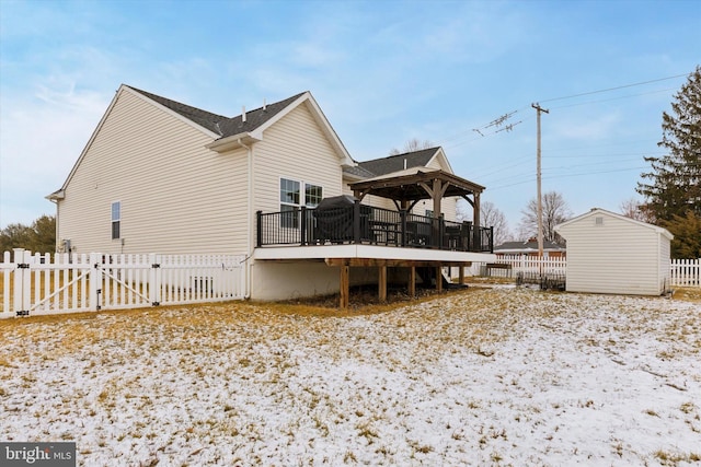 snow covered back of property featuring a wooden deck