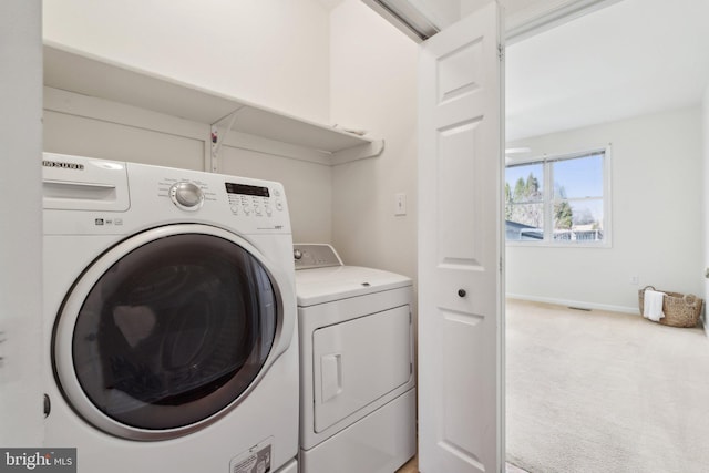 laundry room with carpet floors, laundry area, baseboards, and washing machine and clothes dryer