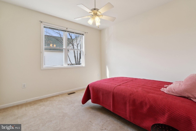 carpeted bedroom featuring visible vents, baseboards, and a ceiling fan