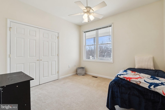 bedroom featuring visible vents, baseboards, a ceiling fan, carpet flooring, and a closet