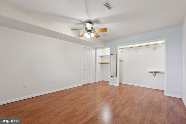 unfurnished bedroom with ceiling fan, wood finished floors, visible vents, and baseboards