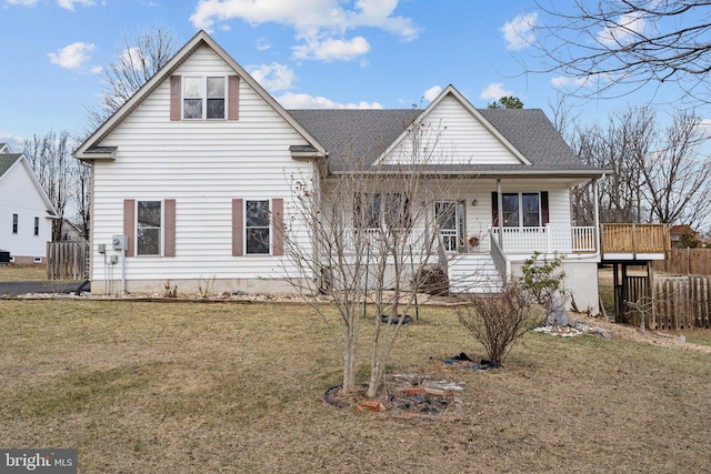 view of front of home with roof with shingles, a porch, and a front yard