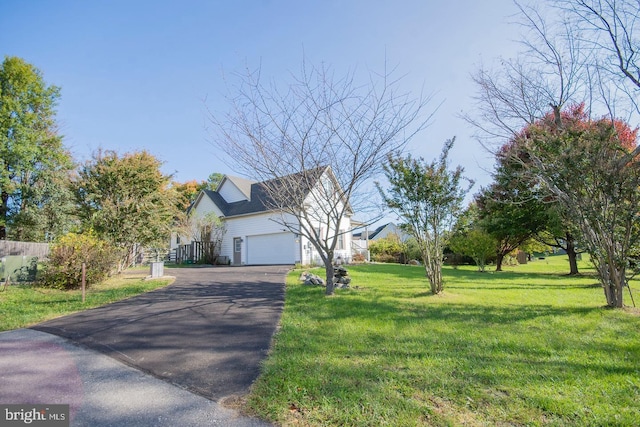 view of property exterior featuring an attached garage, aphalt driveway, and a yard