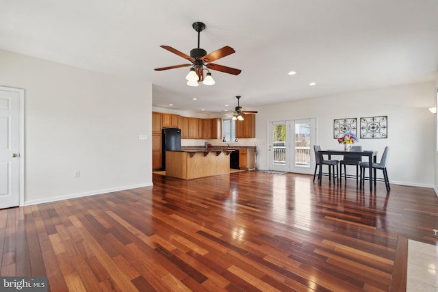 unfurnished living room featuring dark wood-style flooring, recessed lighting, and baseboards