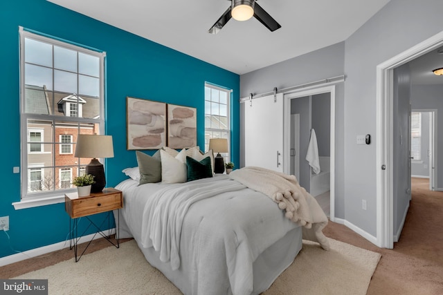 bedroom with light carpet, a barn door, and ceiling fan