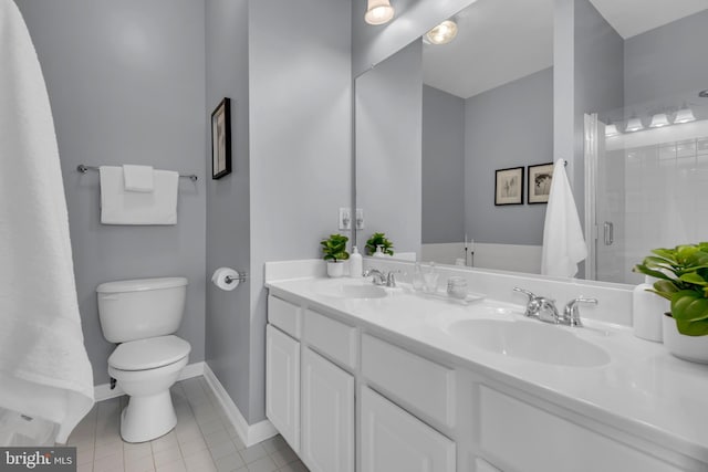 bathroom featuring vanity, tile patterned flooring, a shower with door, and toilet