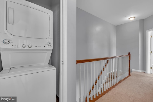 washroom with stacked washer / dryer and carpet