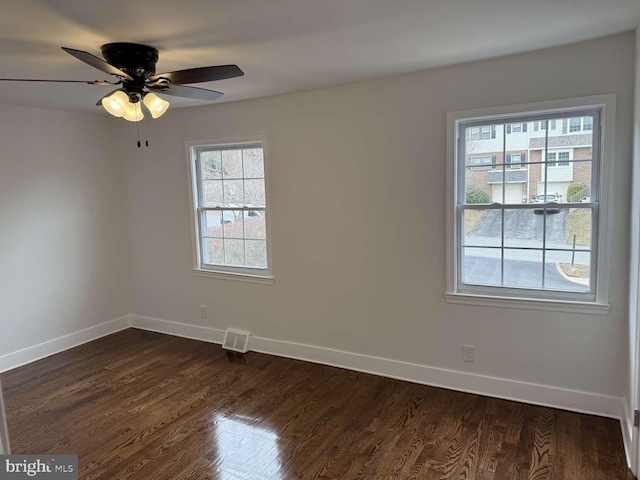 spare room with dark hardwood / wood-style floors and ceiling fan