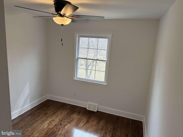 spare room featuring dark wood-type flooring and ceiling fan