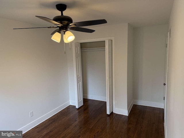 unfurnished bedroom with ceiling fan, dark hardwood / wood-style flooring, and a closet