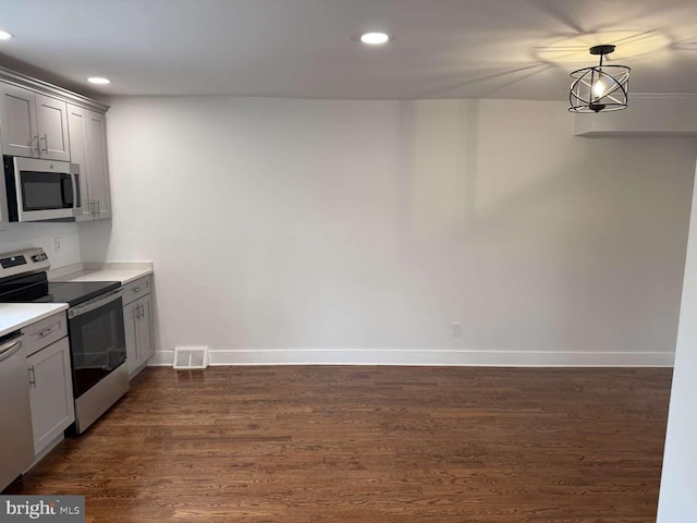 kitchen featuring gray cabinetry, dark hardwood / wood-style flooring, hanging light fixtures, a notable chandelier, and stainless steel appliances