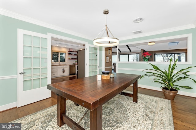 dining room with ornamental molding and hardwood / wood-style floors