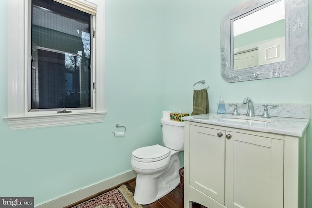 bathroom with hardwood / wood-style flooring, vanity, and toilet