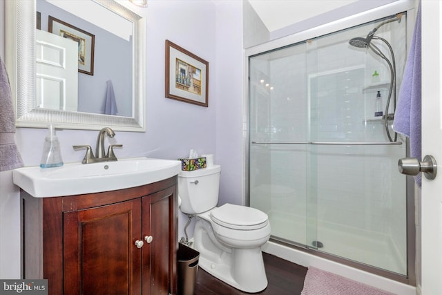 bathroom featuring vanity, toilet, and a shower with door