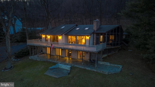 back of house with a wooden deck, a yard, and a patio area