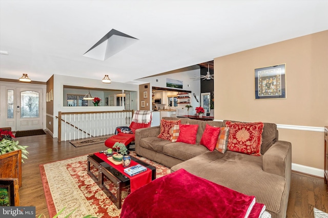 living room featuring a skylight and dark wood-type flooring