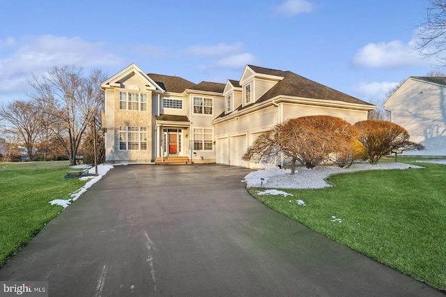 view of property featuring a garage and a front lawn