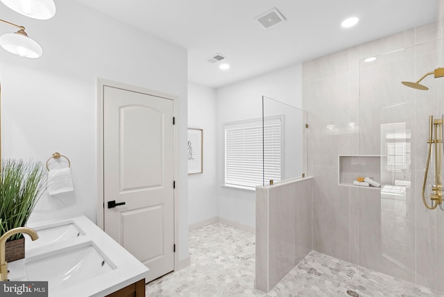 bathroom with a walk in shower, double vanity, a sink, and visible vents