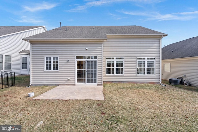 back of property with roof with shingles, central AC unit, a lawn, and a patio area