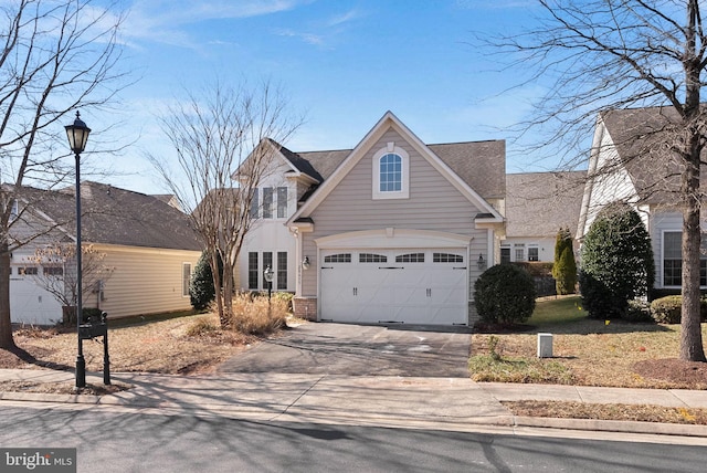 traditional home with a garage, concrete driveway, and brick siding