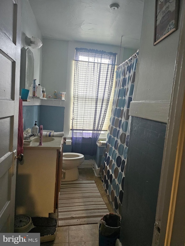 bathroom featuring tile patterned flooring, vanity, and toilet