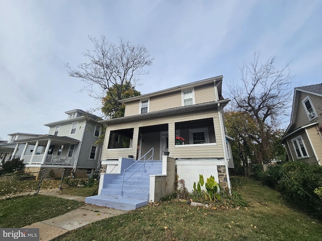 view of property featuring a front lawn and covered porch